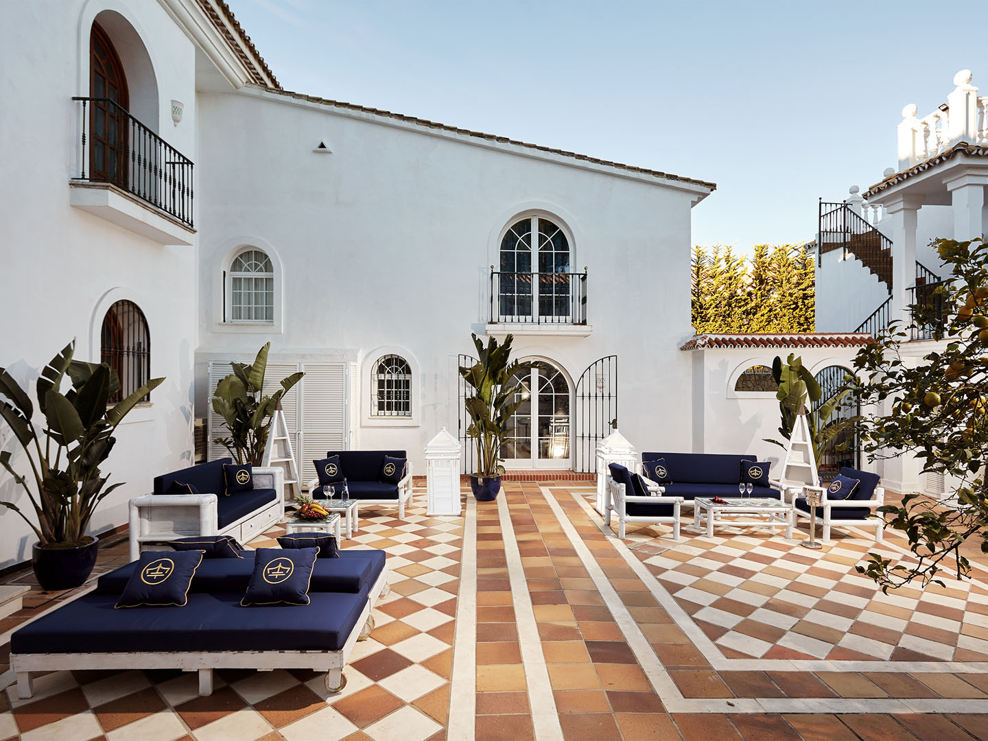 Andalusian courtyard with navy lounges and checkerboard tile
